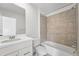 Clean bathroom features a shower-tub combo with ceramic tile, and matching fixtures and cabinets at 17123 W 91St Ln, Arvada, CO 80007