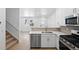 Bright kitchen features stainless steel appliances, white cabinets, and an eat-in breakfast bar at 17123 W 91St Ln, Arvada, CO 80007