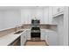 Well-equipped kitchen with stainless steel appliances, white cabinets, and quartz countertops at 17123 W 91St Ln, Arvada, CO 80007