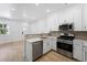 Modern kitchen boasts stainless steel appliances, white cabinetry, and lots of natural light at 17123 W 91St Ln, Arvada, CO 80007