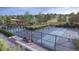 Outdoor pickleball courts surrounded by fencing, landscaping, and trees, offering recreational opportunities for residents at 17123 W 91St Ln, Arvada, CO 80007
