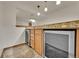Wet bar in basement featuring under-counter storage, granite countertop, tile backsplash, and wine refrigerators at 5722 W Chestnut Ave, Littleton, CO 80128
