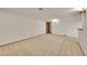 Large finished basement with neutral carpet and base trim with doorway to another room at 5722 W Chestnut Ave, Littleton, CO 80128