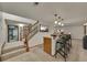 Finished basement area featuring a bar with seating, a staircase, and neutral decor at 5722 W Chestnut Ave, Littleton, CO 80128