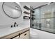 Modern bathroom boasts updated vanity, stylish fixtures, a round mirror and an eye-catching subway tile shower at 5722 W Chestnut Ave, Littleton, CO 80128