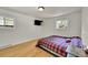 Bright bedroom featuring hardwood floors, two windows for natural light, and a comfortable bed at 5722 W Chestnut Ave, Littleton, CO 80128