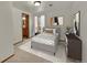 Bedroom featuring a neatly made bed, window with blinds, and a dresser at 5722 W Chestnut Ave, Littleton, CO 80128