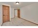 Bright bedroom boasts neutral carpet and wood-stained doors leading to other spaces at 5722 W Chestnut Ave, Littleton, CO 80128