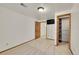 Well-lit bedroom with plush neutral carpet, closet, and access to another room at 5722 W Chestnut Ave, Littleton, CO 80128