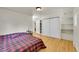 Bedroom features hardwood floors, a bed, and an open closet with shelving for ample storage at 5722 W Chestnut Ave, Littleton, CO 80128