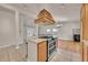Open-concept kitchen features an island cooktop with custom hood and connects to a light filled living space at 5722 W Chestnut Ave, Littleton, CO 80128