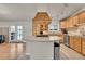 Well-lit kitchen features custom hood vent, tile backsplash, granite countertops, and stainless steel appliances at 5722 W Chestnut Ave, Littleton, CO 80128