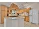 Well-lit kitchen features custom hood vent, tile backsplash, granite countertops, and stainless steel appliances at 5722 W Chestnut Ave, Littleton, CO 80128