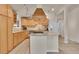 Well-lit kitchen features custom hood vent, tile backsplash, granite countertops, and stainless steel appliances at 5722 W Chestnut Ave, Littleton, CO 80128