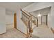 Basement stairs with carpeted steps and decorative railings leading to a finished basement with two doors at 5722 W Chestnut Ave, Littleton, CO 80128