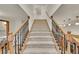 Staircase with carpeted steps, wood railings, and ornate black metal balusters leading to an upper level at 5722 W Chestnut Ave, Littleton, CO 80128