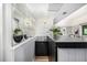 Modern bar area features black countertop, cabinetry and decorative mirrored backsplash at 7234 S Kendall Ct, Littleton, CO 80128