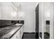 Modern bathroom with white cabinets, marble countertops, and black tile flooring at 7234 S Kendall Ct, Littleton, CO 80128