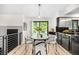 Dining area with modern light fixture, round table, comfortable chairs, and sliding glass doors to backyard at 7234 S Kendall Ct, Littleton, CO 80128