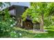 Beautiful exterior elevation featuring lush landscaping with green foliage and blossoming white roses at 7234 S Kendall Ct, Littleton, CO 80128