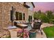 Back patio with seating area, fire pit, grill, and lush landscaping at 14370 Osage St, Westminster, CO 80023
