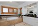 Luxurious bathroom featuring a soaking tub, white cabinets, dark countertops and shuttered windows for natural light at 14370 Osage St, Westminster, CO 80023