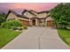 Inviting two-story home featuring a stone-accented facade, solar panels, a well-manicured lawn, and a large driveway at 14370 Osage St, Westminster, CO 80023