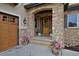 Beautiful stone entryway featuring a wood door with a wreath, potted plants, and a lantern-style light fixture at 14370 Osage St, Westminster, CO 80023