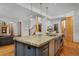 Open concept kitchen with granite island, stainless steel appliances, and wood floors at 14370 Osage St, Westminster, CO 80023