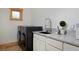 Modern laundry room with black washer/dryer and granite countertops at 14370 Osage St, Westminster, CO 80023