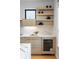 Modern kitchen features light wood cabinetry, floating shelves, white marble countertops and a sleek wine refrigerator at 2160 Folsom St, Boulder, CO 80302