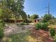 Large backyard with mature trees, garden beds, and a charming storage shed at 14050 E 25Th Pl, Aurora, CO 80011