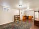 Spacious finished basement with a large area rug, bookshelves, and a work/sewing area at 14050 E 25Th Pl, Aurora, CO 80011