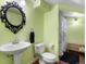 A full bathroom with a pedestal sink, toilet, large mirror, and a shower with curtain at 14050 E 25Th Pl, Aurora, CO 80011