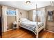 Serene bedroom featuring hardwood floors, soft lighting, and a comfortable bed, creating a relaxing and inviting retreat at 14050 E 25Th Pl, Aurora, CO 80011
