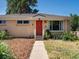 Inviting home featuring a brick facade, manicured lawn, and a striking red door, creating a warm and appealing curb appeal at 14050 E 25Th Pl, Aurora, CO 80011