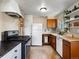 Functional kitchen with essential appliances, wooden cabinets, and vintage tile flooring, ready for your culinary creations at 14050 E 25Th Pl, Aurora, CO 80011