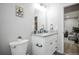 Bright bathroom with a white vanity, granite countertop, and a view into the adjacent living space at 2696 S Grove St, Denver, CO 80219