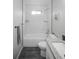 Bathroom featuring white tile, bath, and a vanity with a granite counter top and storage at 2696 S Grove St, Denver, CO 80219