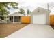 Charming home exterior with a freshly painted gray exterior, detached garage, and long driveway at 2696 S Grove St, Denver, CO 80219