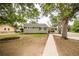 Inviting home exterior with a carport, well-maintained lawn, and mature trees at 2696 S Grove St, Denver, CO 80219
