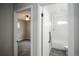 Bright hallway showcasing doorways to a bedroom with a ceiling fan and a bathroom with white tiles at 2696 S Grove St, Denver, CO 80219