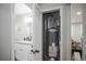 View of a utility closet and a doorway into a bathroom with a sink and mirror at 2696 S Grove St, Denver, CO 80219