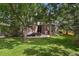 Backyard featuring a well-manicured lawn, mature trees, and a patio with outdoor seating and a grill at 16326 E Dorado Ave, Centennial, CO 80015