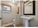 Elegant powder room with pedestal sink, decorative mirror, and stylish lighting at 16326 E Dorado Ave, Centennial, CO 80015