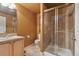 Bathroom featuring a glass-enclosed tiled shower, vanity with sink, and toilet with a tiled floor at 16326 E Dorado Ave, Centennial, CO 80015