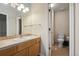 Bright bathroom with oak vanity, mirror, tile, and a separate toilet room at 16326 E Dorado Ave, Centennial, CO 80015