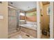 Luxurious bathroom boasts a glass-enclosed shower and a soaking tub with a window at 16326 E Dorado Ave, Centennial, CO 80015