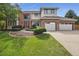 Attractive two-story home featuring a manicured lawn and a three-car garage, blending brick and stucco at 16326 E Dorado Ave, Centennial, CO 80015