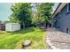 Backyard with a lush green lawn, mature trees, and storage shed at 4854 S Parfet St, Littleton, CO 80127